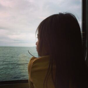 girl looking out window of boat