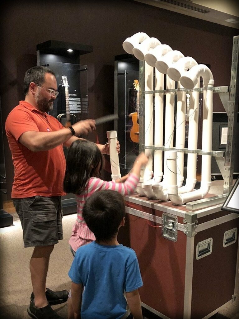 A world schooling family learning about sound and music at the Museum of the Rockies
