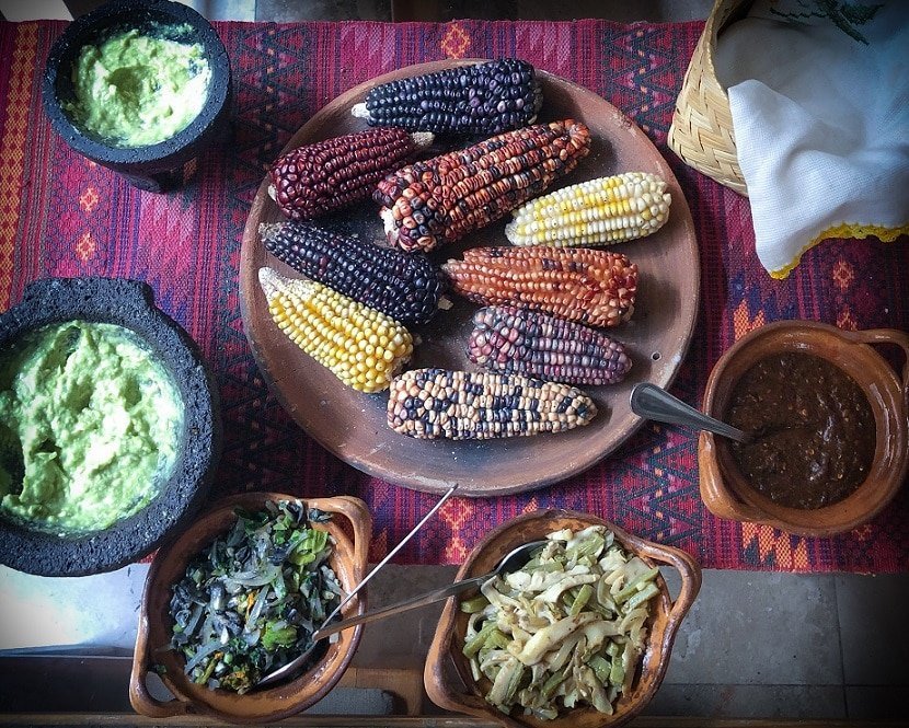 I love Mexico for its food! Dried corn on a platter, surrounded by Mexican dishes of guacamole, sauteed corn fungus, sauteed squash blossom, mole, and tortilla.