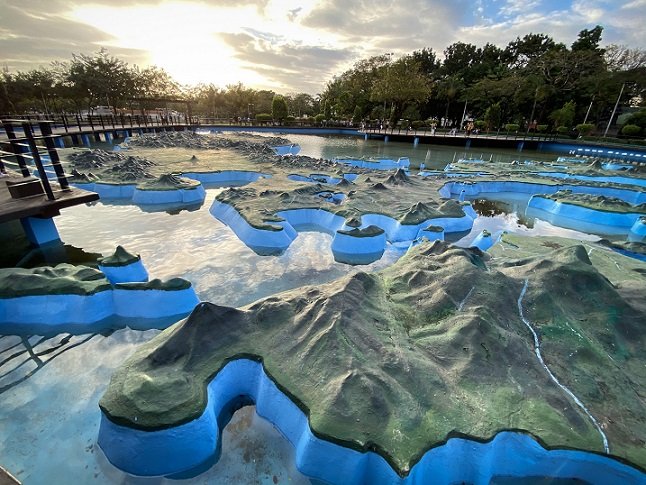 Relief map of the Philippines surrounded by water at Rizal Park, where tourists can visiting during a one day in Manila trip
