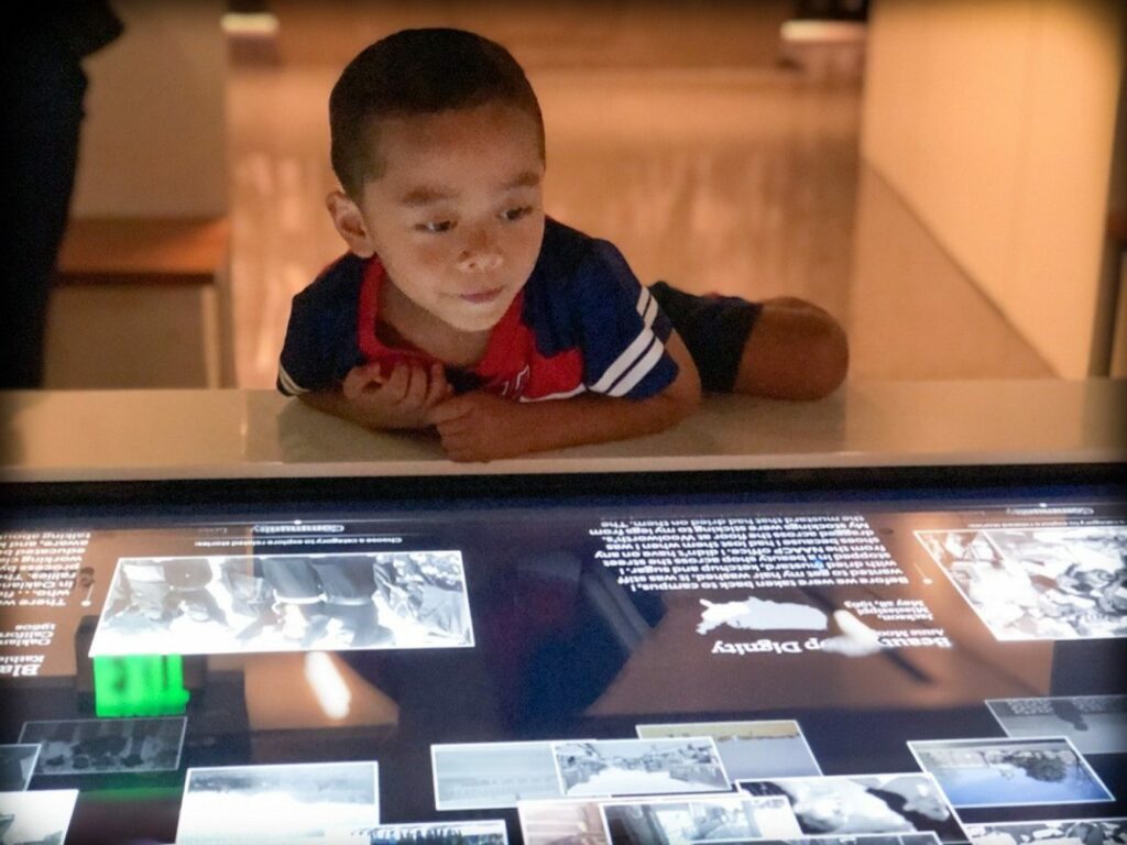 A child using a museum exhibit as worldschooling resources