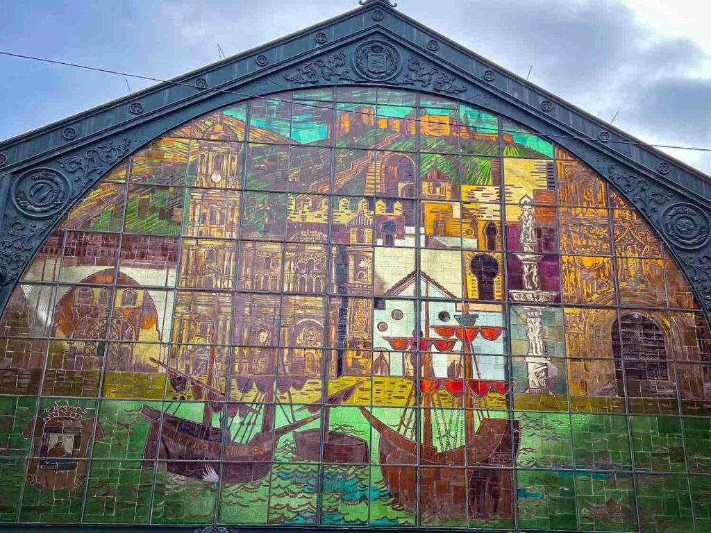 A stained glass window showing three Spanish ships coming into a port at Mercado Central in Malaga during an Andalucia road trip