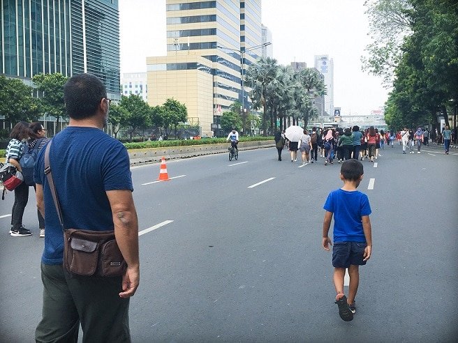 A man and boy walking through the streets of Jakarta while traveling with kids in Indonesia