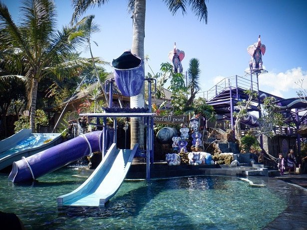 Slides and a giant splash bucket at a pool at Toya Devasya Bali hot springs.