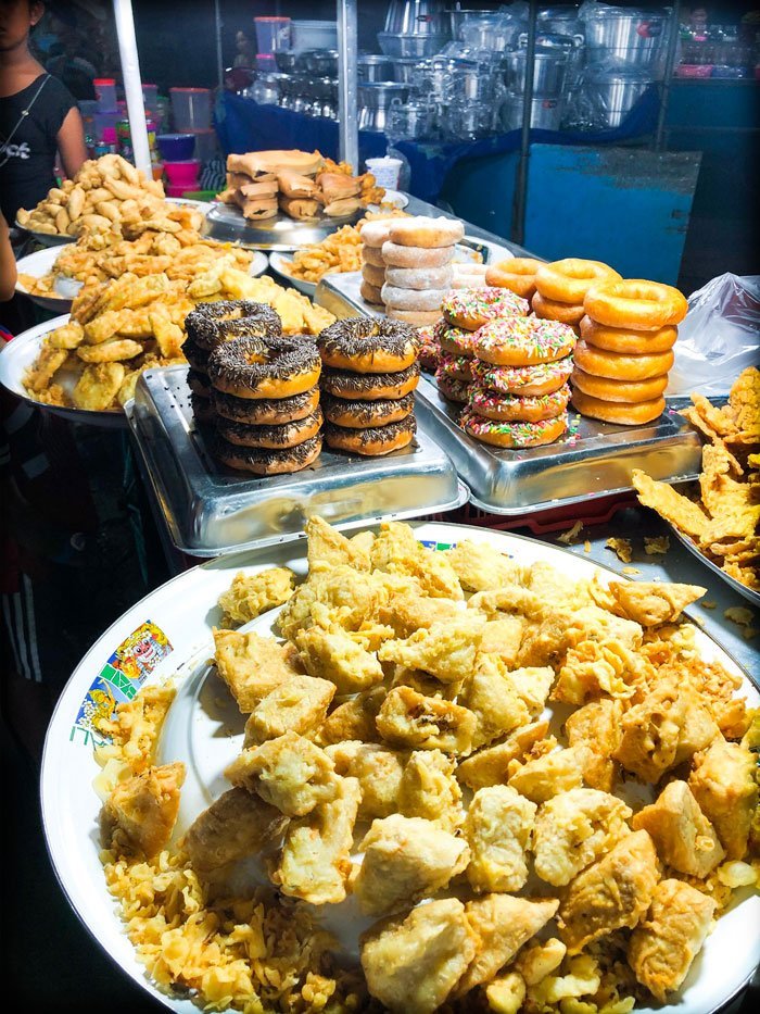 Fried treats, fried doughnuts, and fried tempe on sale at a food stall at a Bali night market in Gianyar, Indonesia