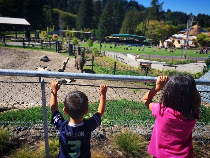 A boy and girl looking at an elephant exhibit at the Oregon Zoo, one of the top things to do in Portland