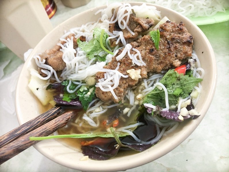 A bowl of bun cha mixed with vermicelli noodles and vegetables, a popular food in Hanoi