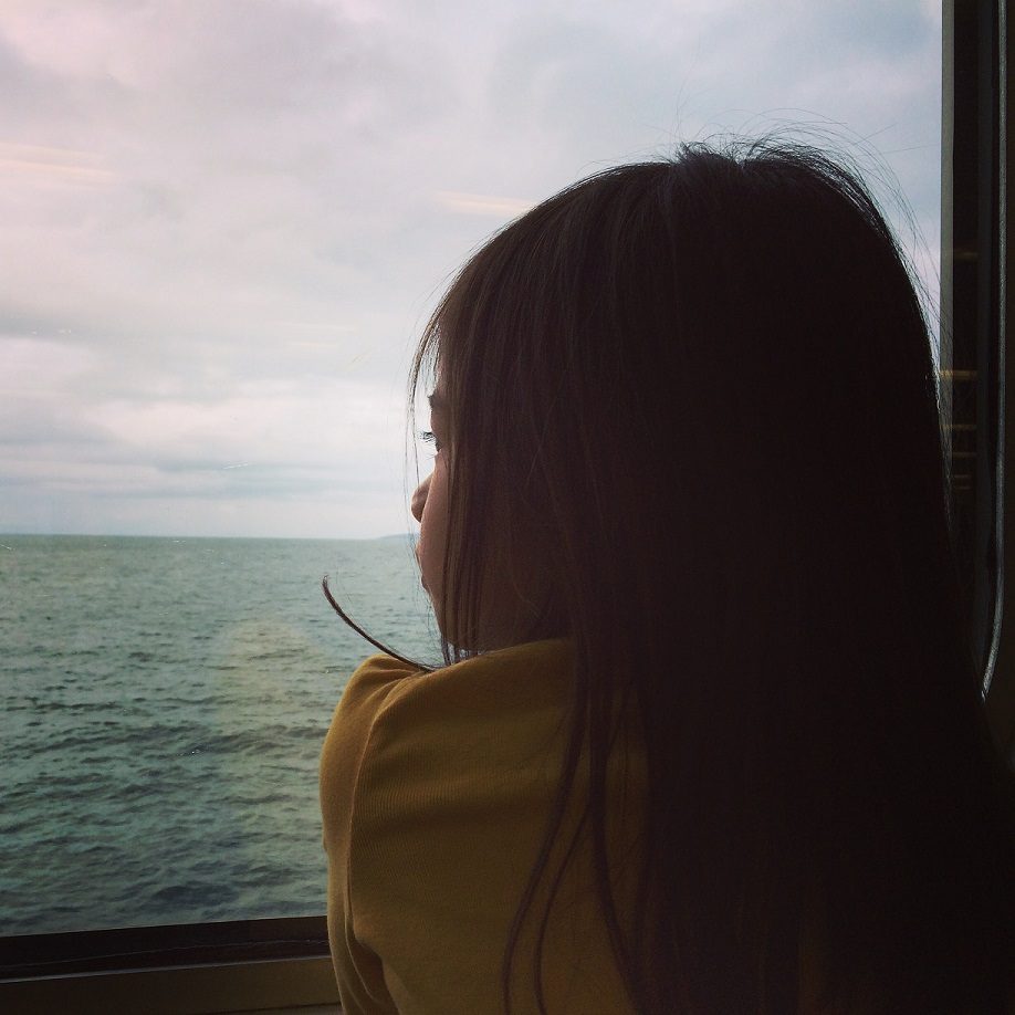 girl looking out window of boat, experiencing the educational benefits of travel