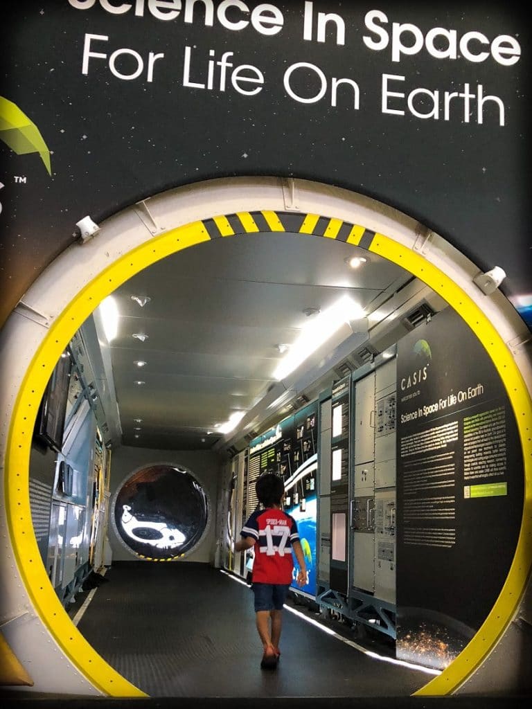 A boy walks through a space exhibit at Wings Over the Rockies museum, an example of family friendly Denver experiences.