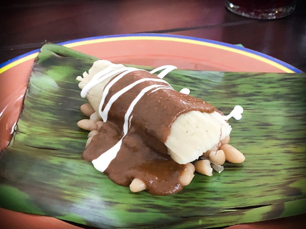 Tamale with mole over cooked beans made at a Mexican cooking class in Puerto Vallarta