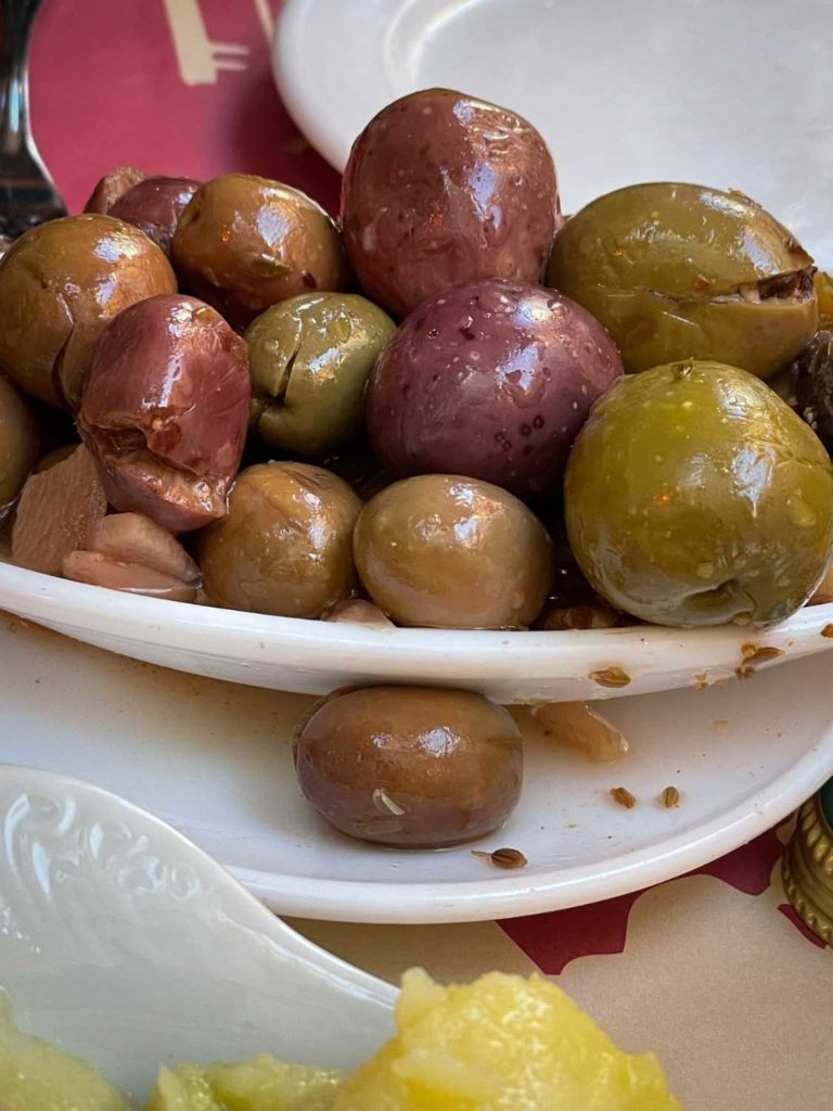 Colorful olives in olive oil in a white dish