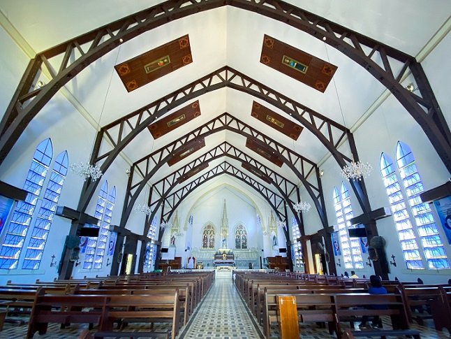 Interior of the Immaculate Conception Cathedral in Puerto Princesa, Philippines. The altar is in the background, in the center is the aisle, with pews on either side of the aisle