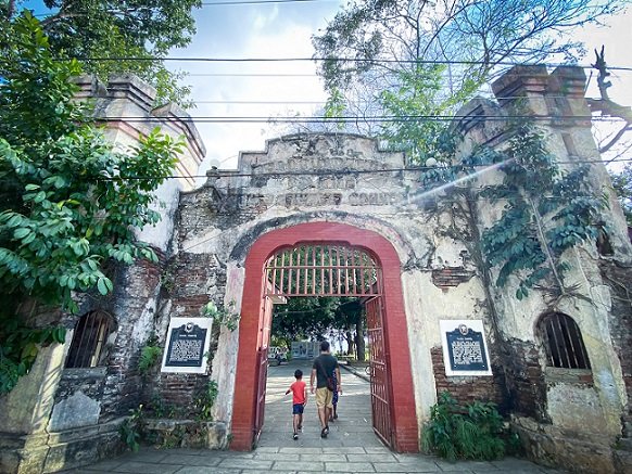 Visitors walking through the main gate of Plaza Cuartel in Puerto Princesa, Philippines