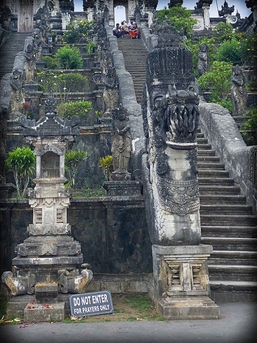 Decorative steps at Pura Lempuyang, home of the Gates of Heaven in Bali. A stone offering stand in the foreground, next to a stone dragon which decorates the front of the steps.