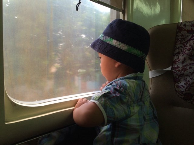 A kid riding the train in Indonesia, traveling internationally with kids