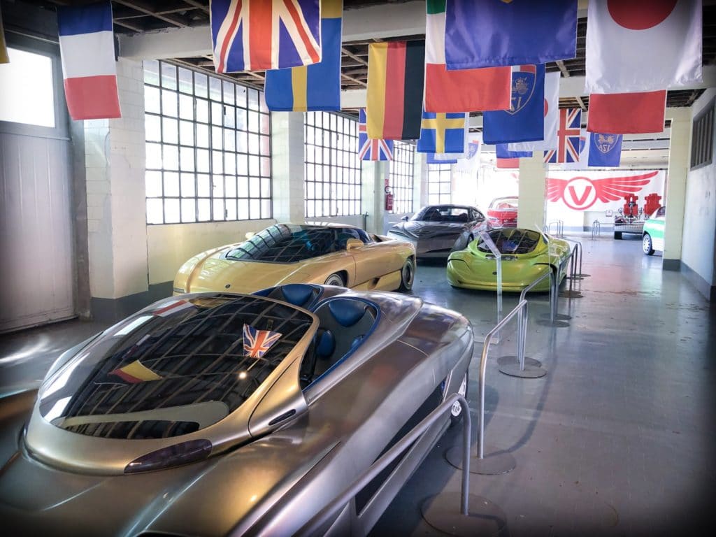 Four concept cars on display in a row at a Volandia museum in Milan, Italy. The cars are sports cars, with tinted glass.