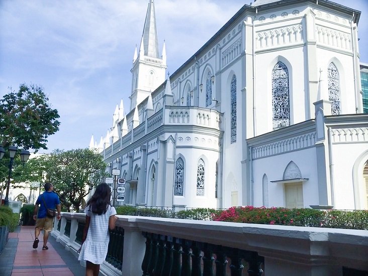 A man and girl walk by the former chapel at the Chijmes complex, one of the things to do in Singapore on a budget