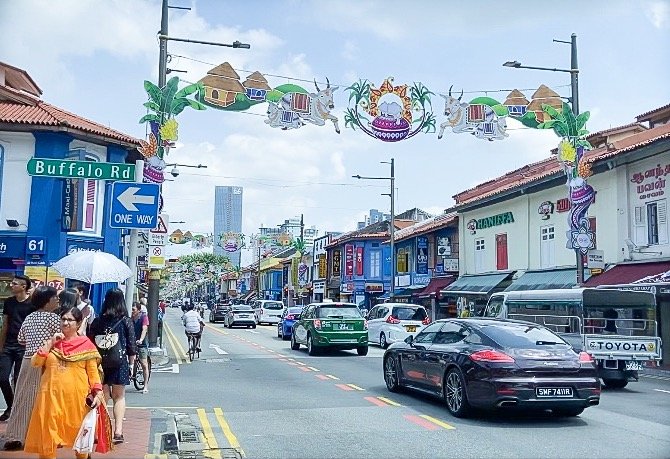 Pedestrians and cars along Serangoon Road in Little India, one of the places to visit for things to do in Singapore on a budget 