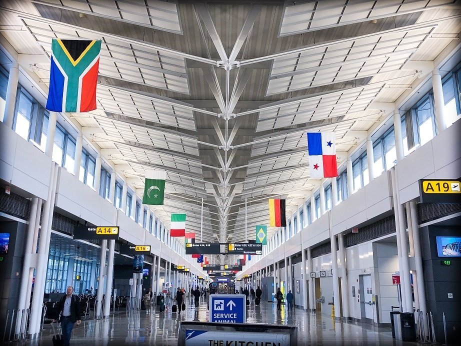 Flags from around the world hanging from the ceiling at an airport terminal